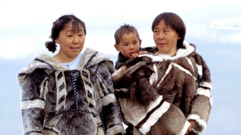 Iglulingmiut Inuit women and child in traditional parkas Two Iglulingmiut Inuit women in traditional parkas, one is carrying a child behind her