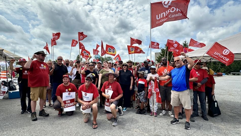 Group photo with on strike signs and red unifor flags