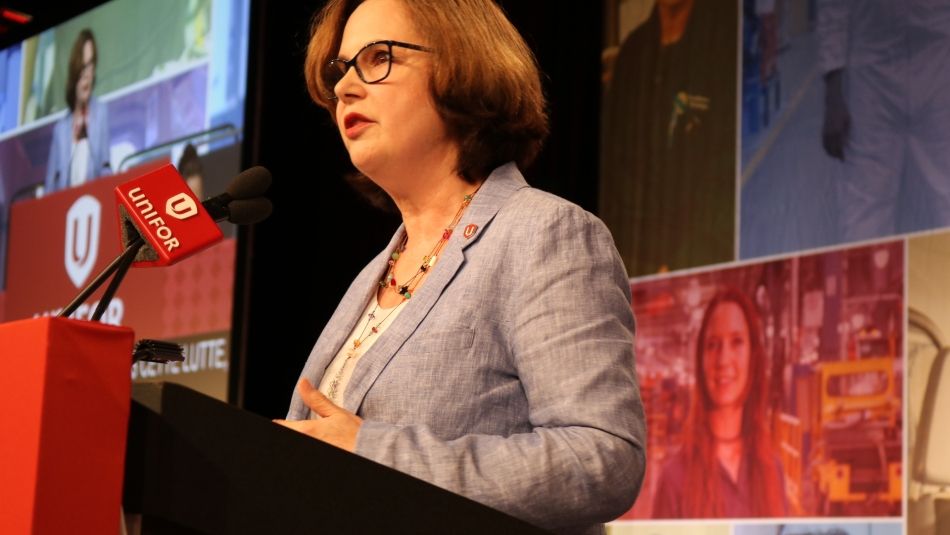 Joie Warnock addresses Canadian Council delegates from the podium.