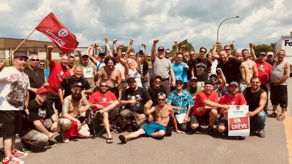 Dozens of members of Local 6000 raise their fists in solidarity.