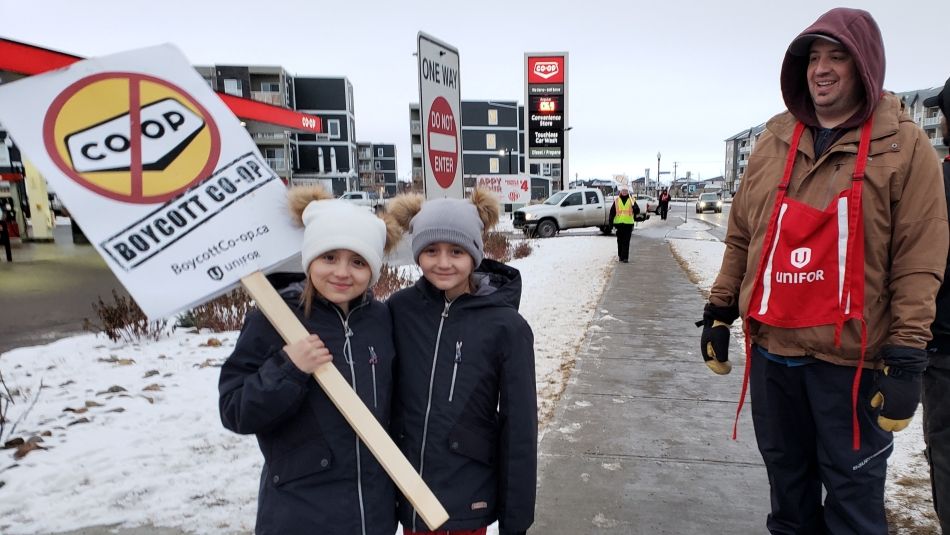 A Unifor member's children hold a sign at an information picket for locked-out Unifor Local 594 members..