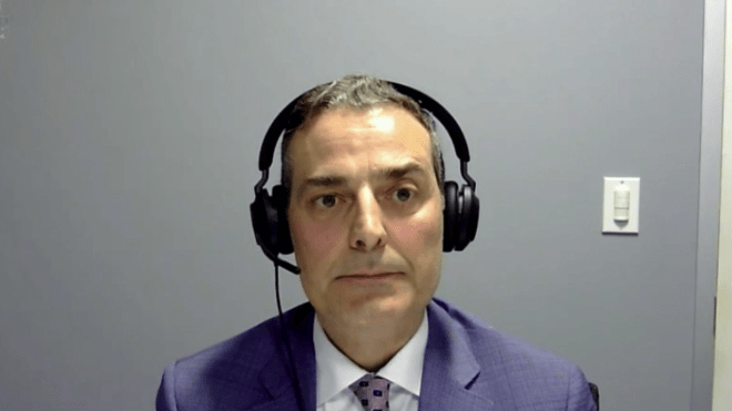 A man wearing a blue suit with headphones.