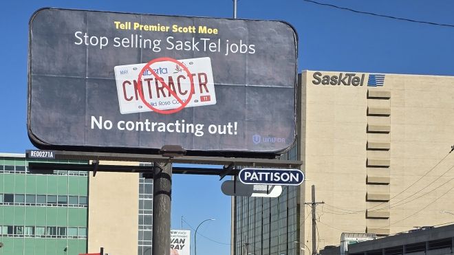 A billboard reading "Tell Premier Scott Moe Stop Selling SaskTel Jobs, No contracting out!" and an office tower with SaskTel signage in the background.