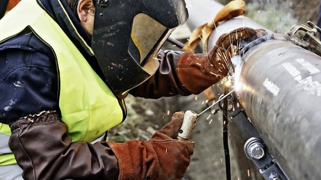 A person welding a large pipe