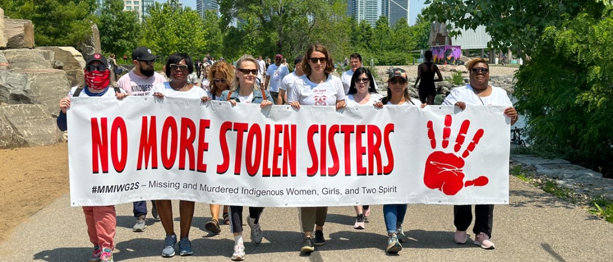 Group marching holding a banner reading No More Stolen Sisters