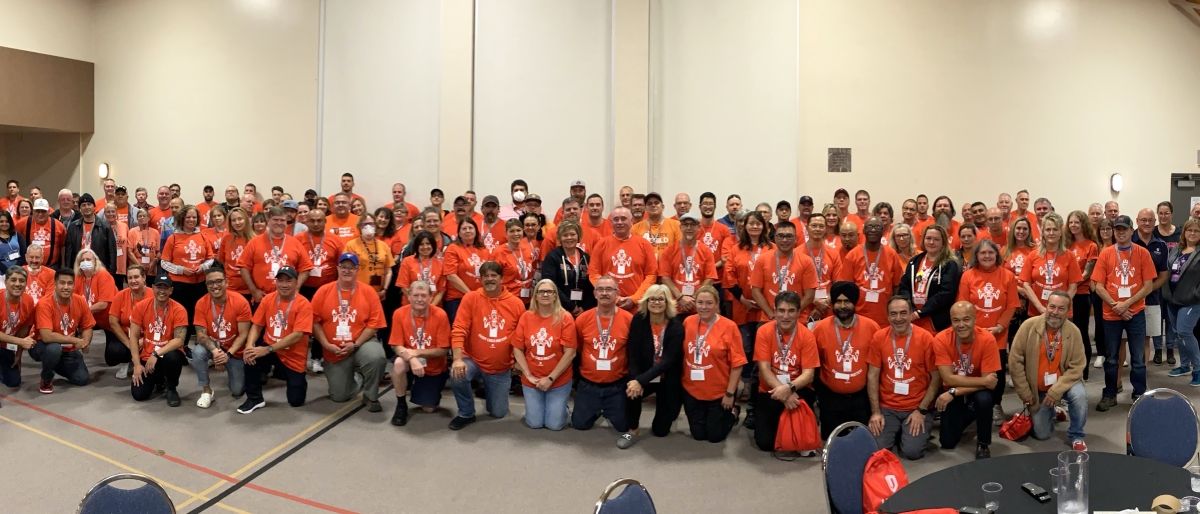 Une grande photo de groupe : tout le monde porte des t-shirts orange "every child matters" (chaque enfant compte).