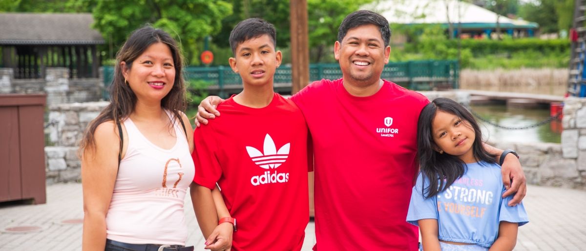 An asian family arm around each other smiling 